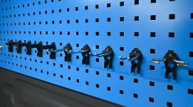 Panel perforado de pared con una serie de ganchos de metal y plástico