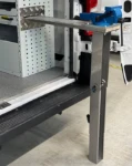 Pata extensible para portatornillos de banco extraíble, abierta y apoyada en el suelo