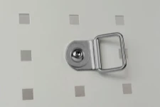 Gancho basculante en acero fijado al costado del equipamiento